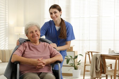 Photo of Caregiver covering senior woman with blanket indoors. Home health care service