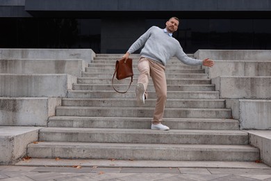 Photo of Man falling on stairs outdoors. Dangerous accident