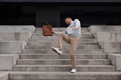 Photo of Man falling on stairs outdoors. Dangerous accident