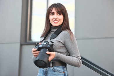 Photo of Professional photographer with digital camera near building outdoors