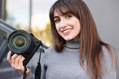 Photo of Professional photographer with digital camera near building outdoors