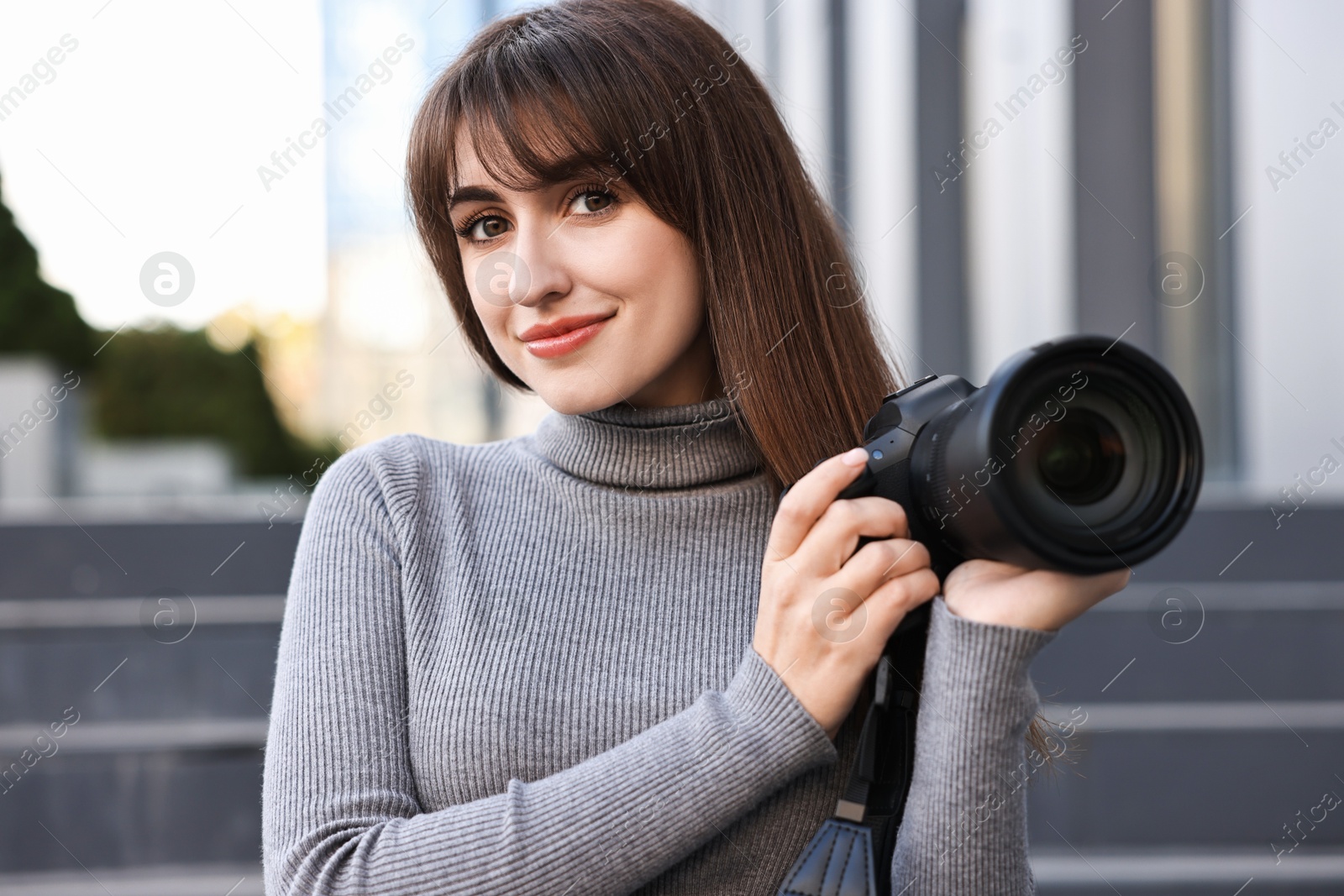 Photo of Professional photographer with digital camera near building outdoors