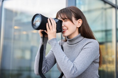 Professional photographer taking picture with camera outdoors