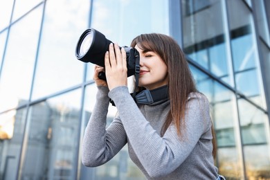 Photo of Professional photographer taking picture with camera outdoors