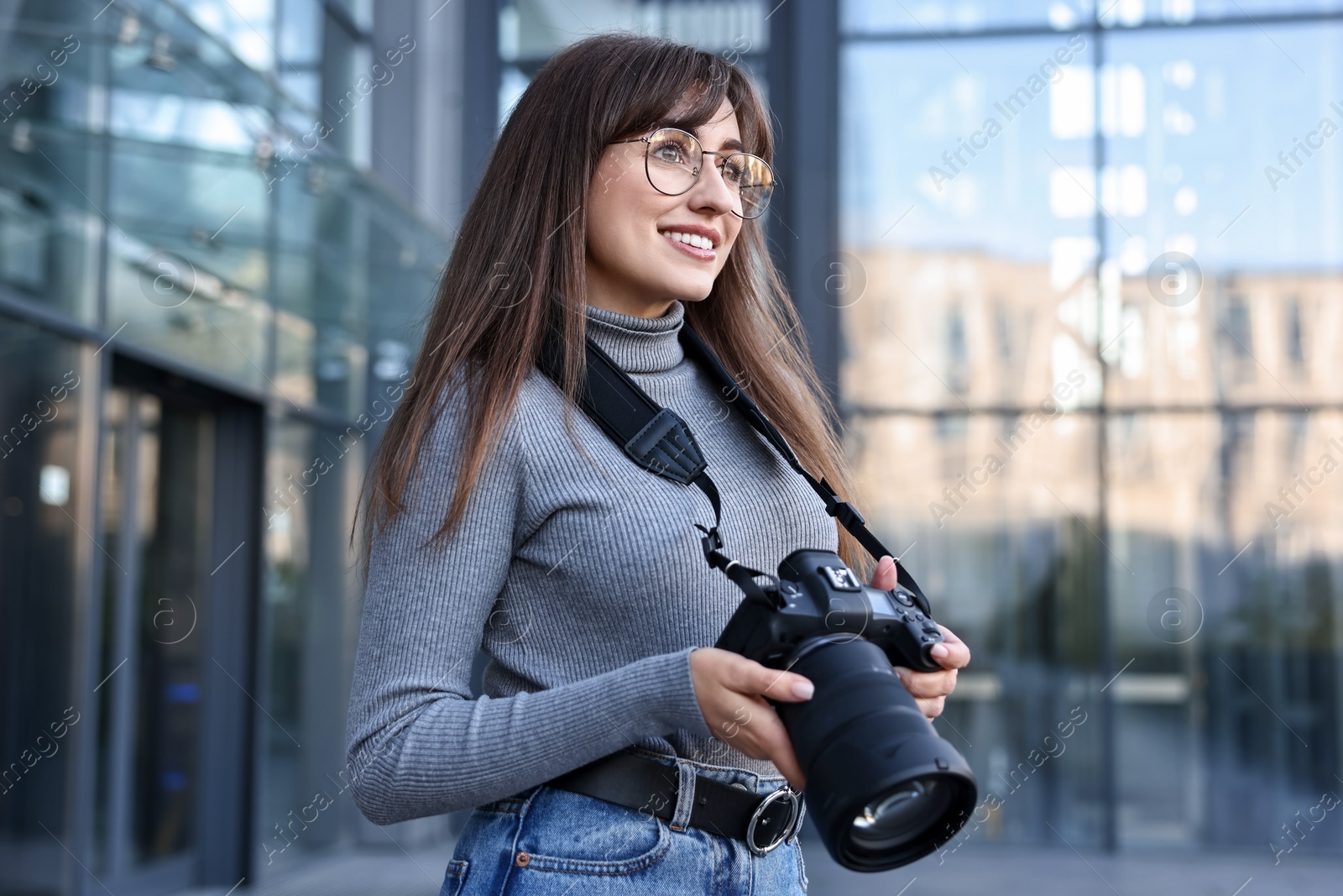 Photo of Professional photographer with digital camera near building outdoors