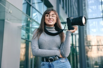 Photo of Professional photographer with digital camera near building outdoors