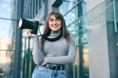 Photo of Professional photographer with digital camera near building outdoors