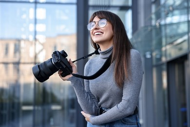 Photo of Professional photographer with digital camera near building outdoors