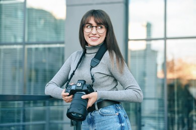 Photo of Professional photographer with digital camera near building outdoors