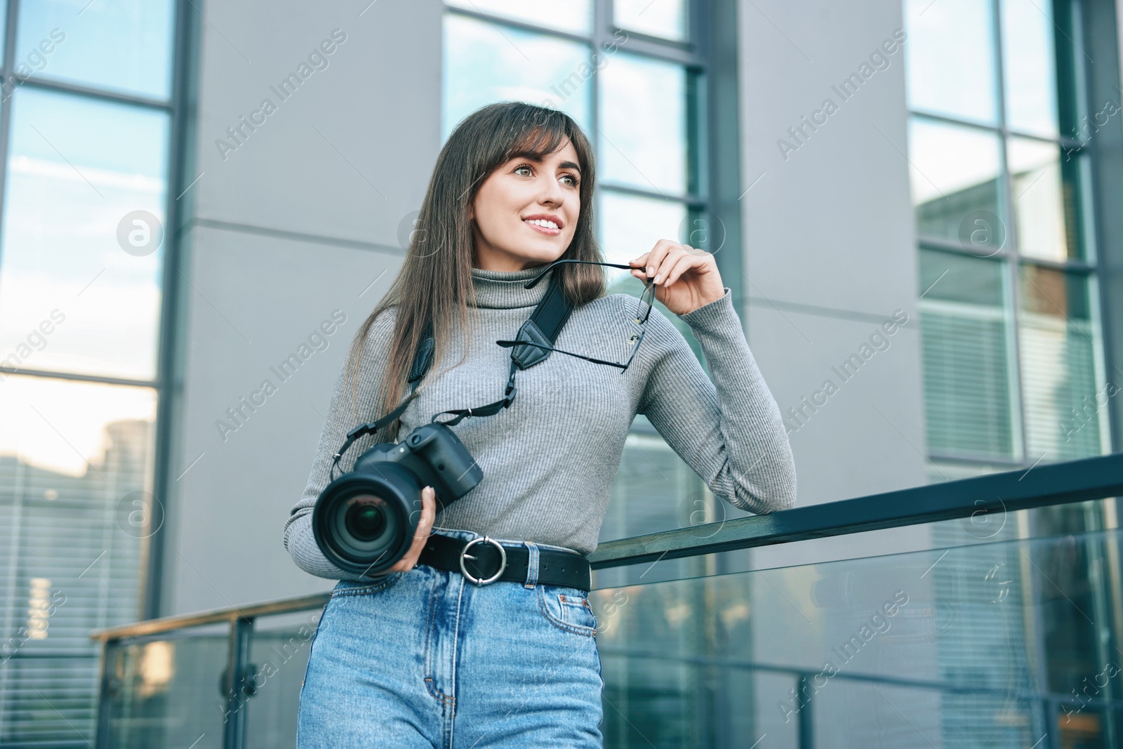 Photo of Professional photographer with digital camera near building outdoors