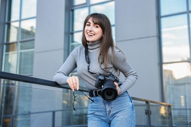 Photo of Professional photographer with digital camera near building outdoors