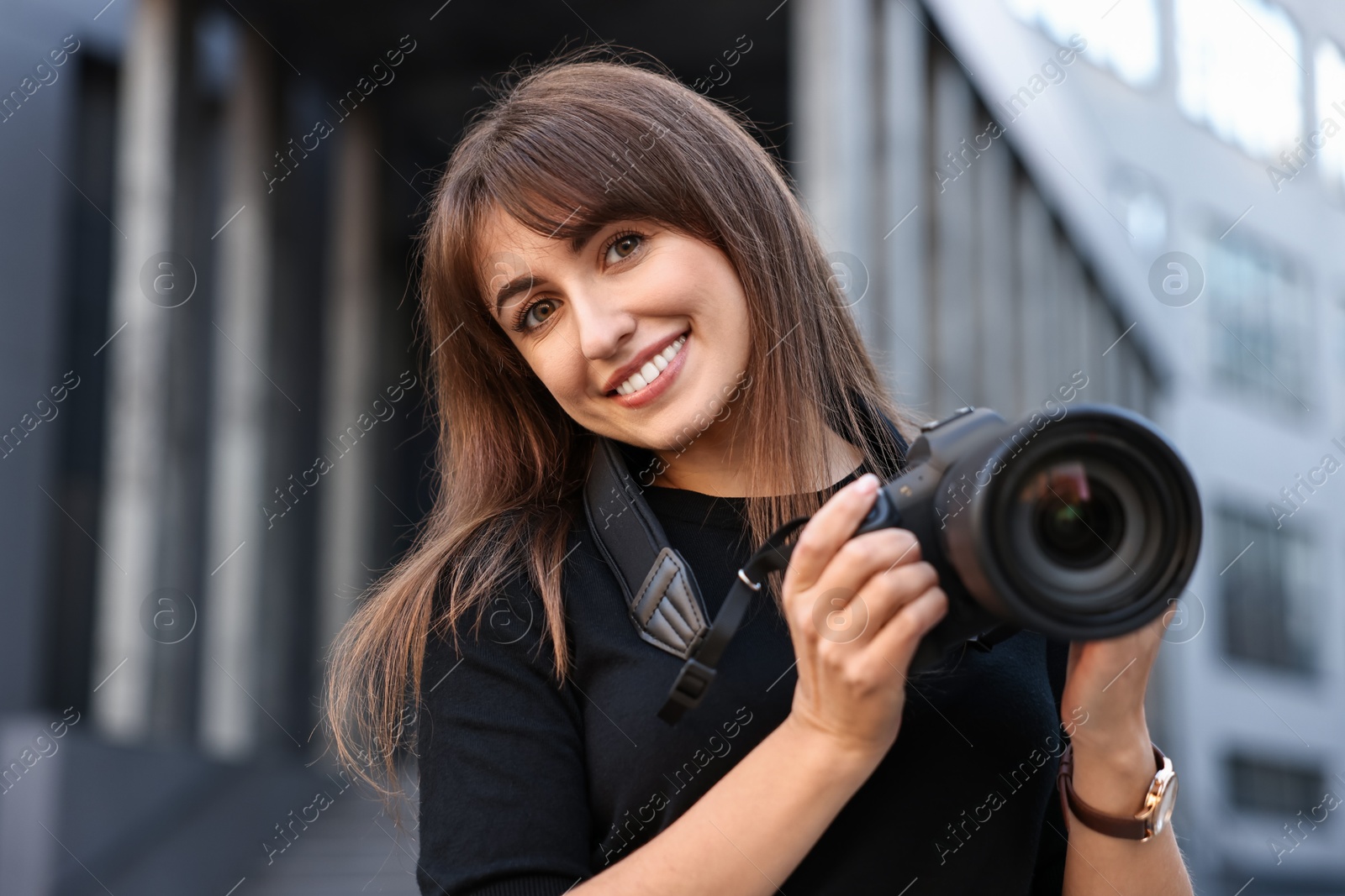 Photo of Professional photographer with digital camera near building outdoors