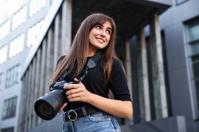 Photo of Professional photographer with digital camera near building outdoors