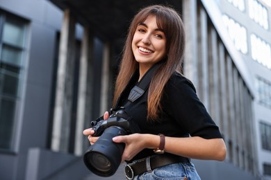 Photo of Professional photographer with digital camera near building outdoors