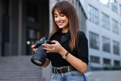 Professional photographer with digital camera near building outdoors