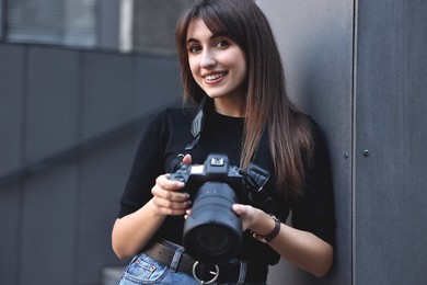 Photo of Professional photographer with digital camera near building outdoors