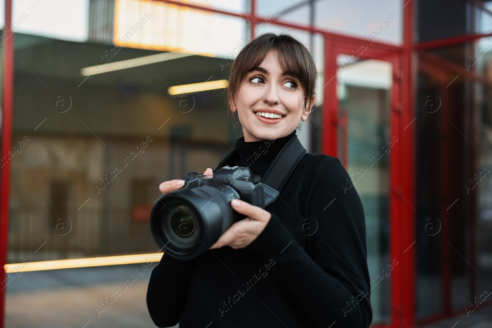 Photo of Professional photographer with digital camera near building outdoors