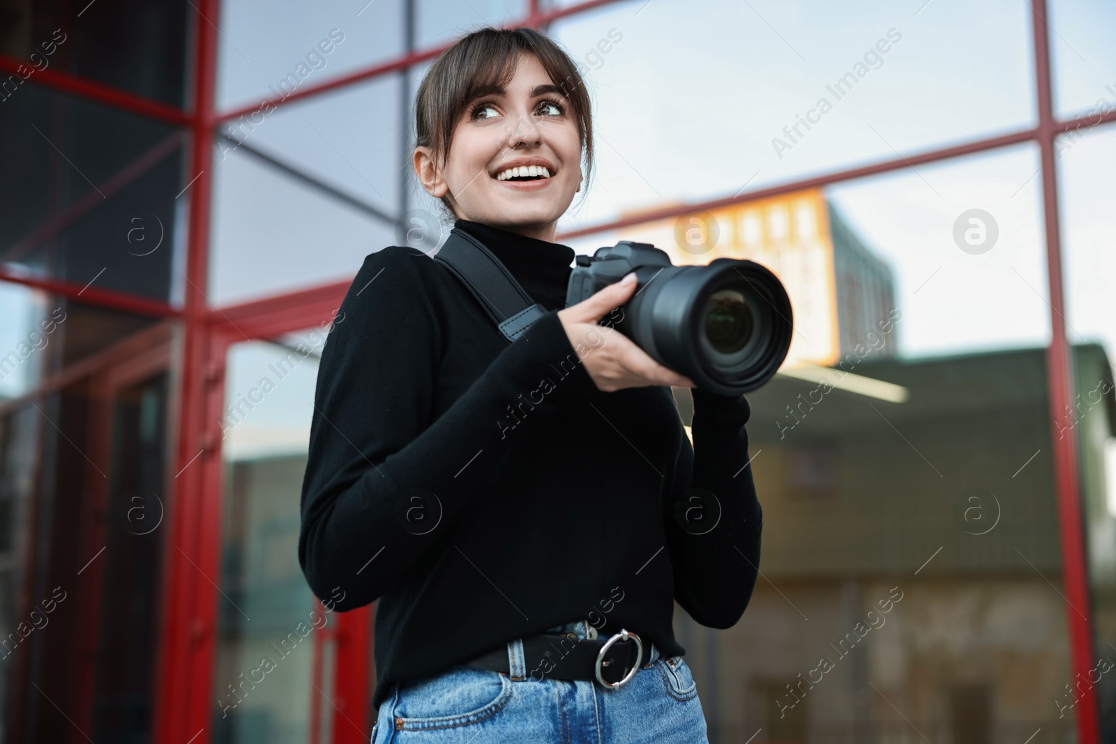 Photo of Professional photographer with digital camera near building outdoors