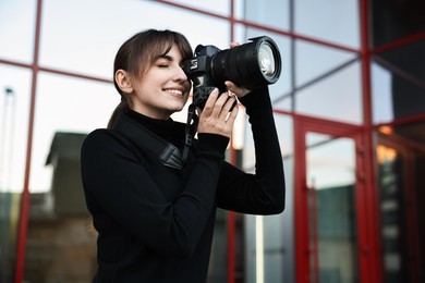 Photo of Professional photographer taking picture with camera outdoors