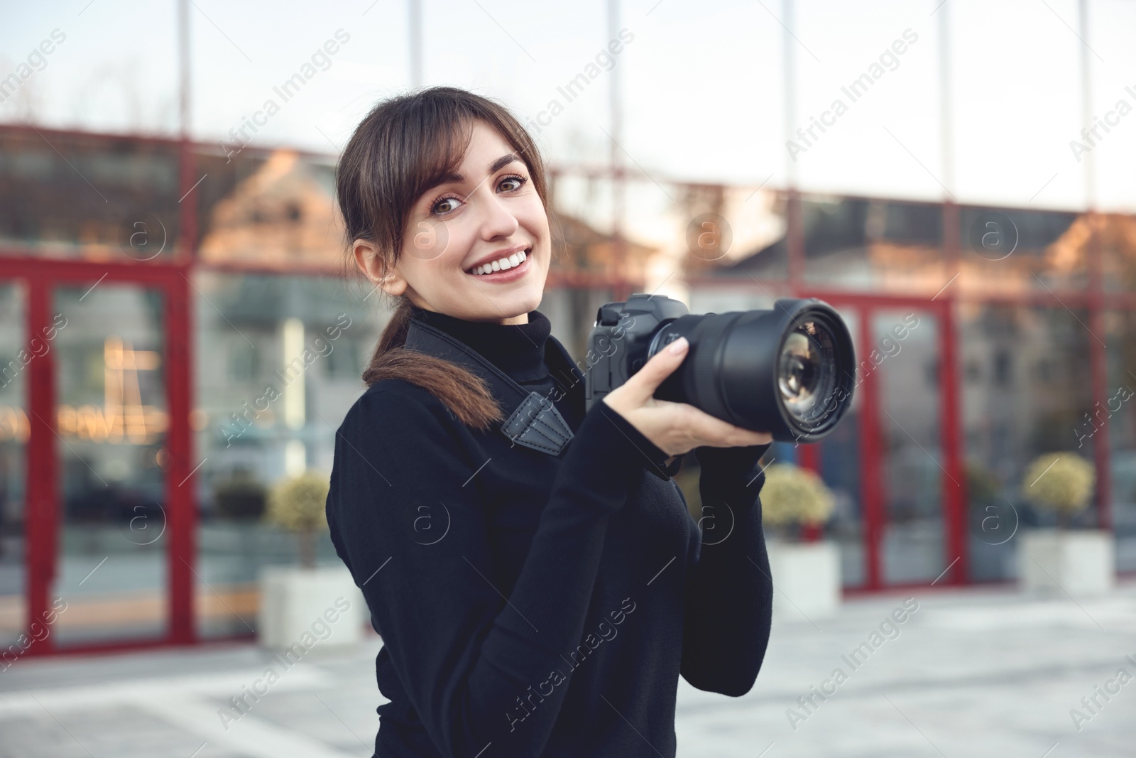 Photo of Professional photographer with digital camera near building outdoors