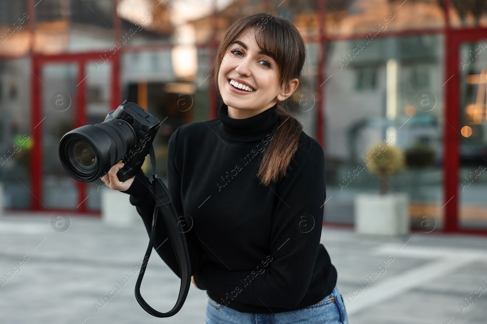 Photo of Professional photographer with digital camera near building outdoors