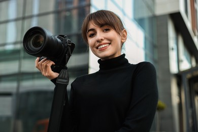 Photo of Professional photographer with digital camera near building outdoors