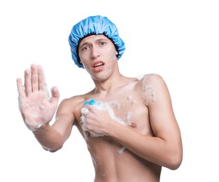 Photo of Man with shower cap and mesh sponge making stop gesture on white background