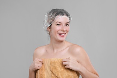 Woman in shower cap on grey background