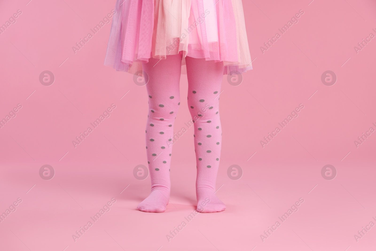 Photo of Child wearing tights on pink background, closeup