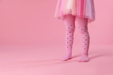 Photo of Child wearing tights on pink background, closeup. Space for text