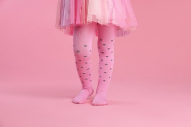 Photo of Child wearing tights on pink background, closeup