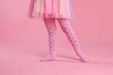 Photo of Child wearing tights on pink background, closeup