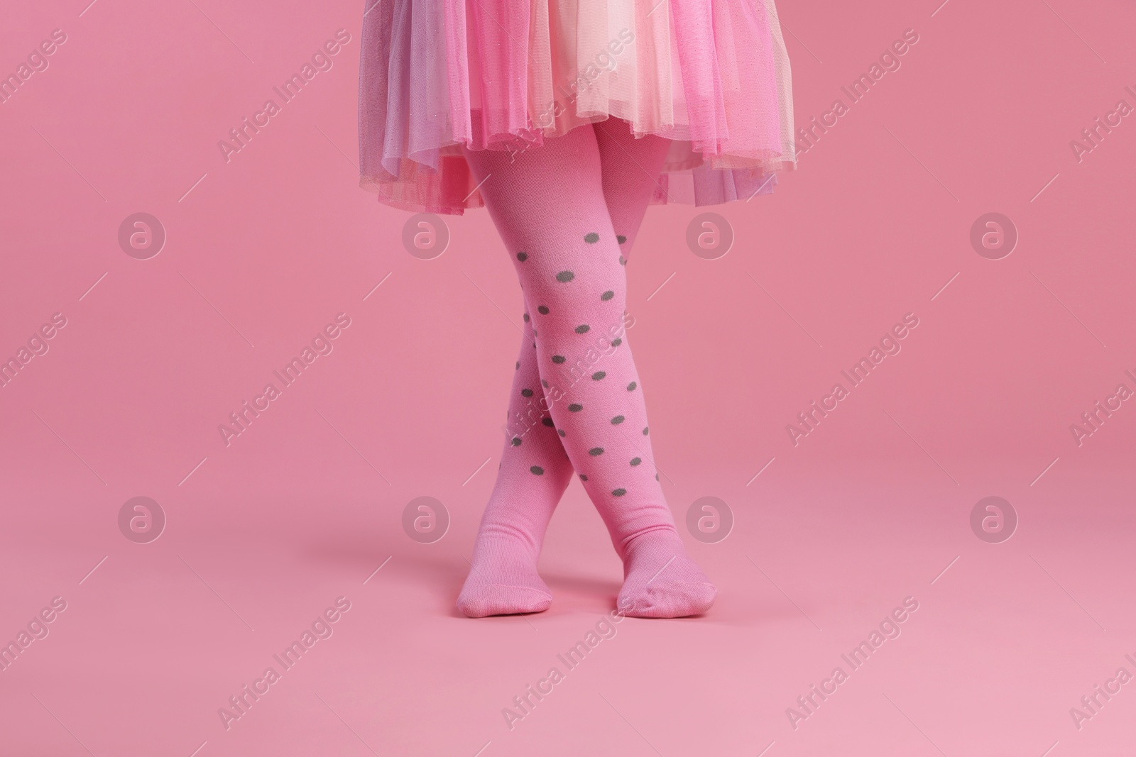 Photo of Child wearing tights on pink background, closeup