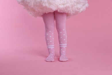 Photo of Child wearing tights on pink background, closeup