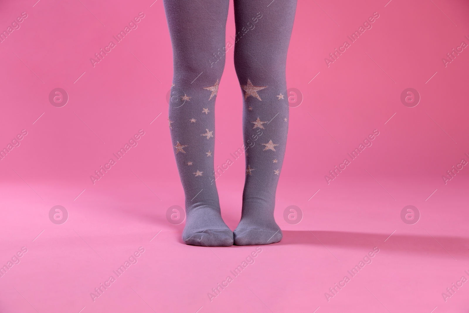 Photo of Child wearing tights on pink background, closeup