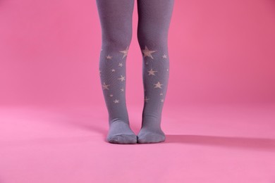 Photo of Child wearing tights on pink background, closeup