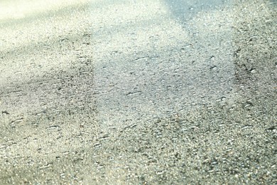 Photo of Water drops on grey glass surface, closeup