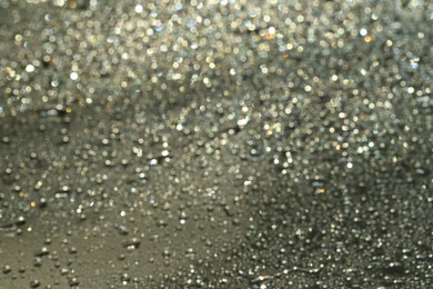 Photo of Water drops on grey glass surface, closeup