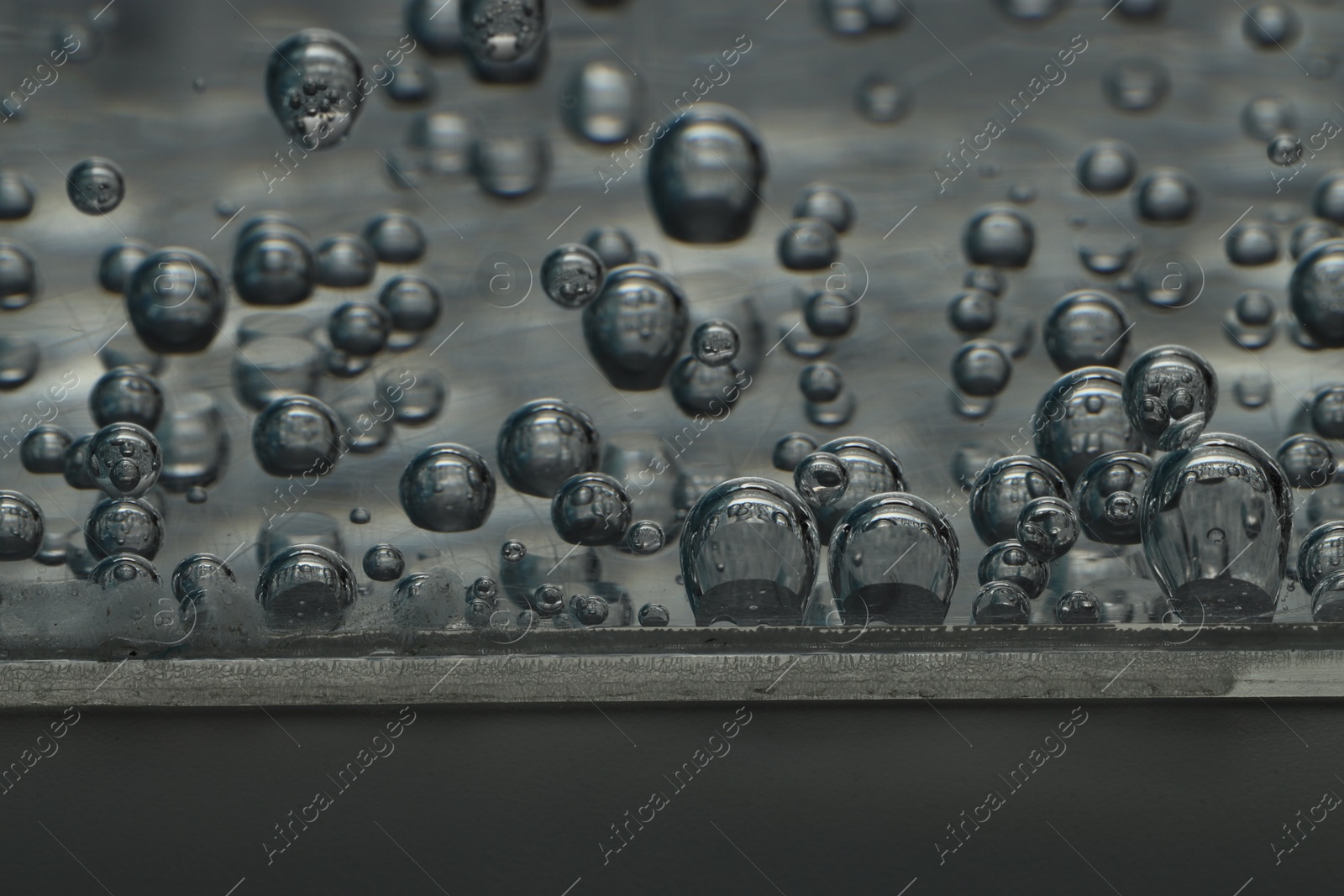 Photo of Soda water with bubbles of gas in glass, closeup