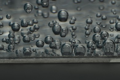 Soda water with bubbles of gas in glass, closeup