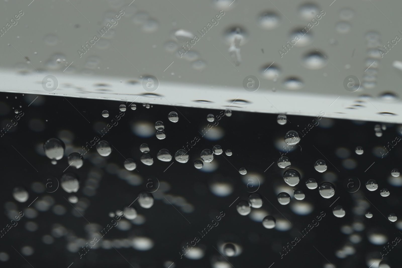 Photo of Soda water with bubbles of gas in glass, closeup