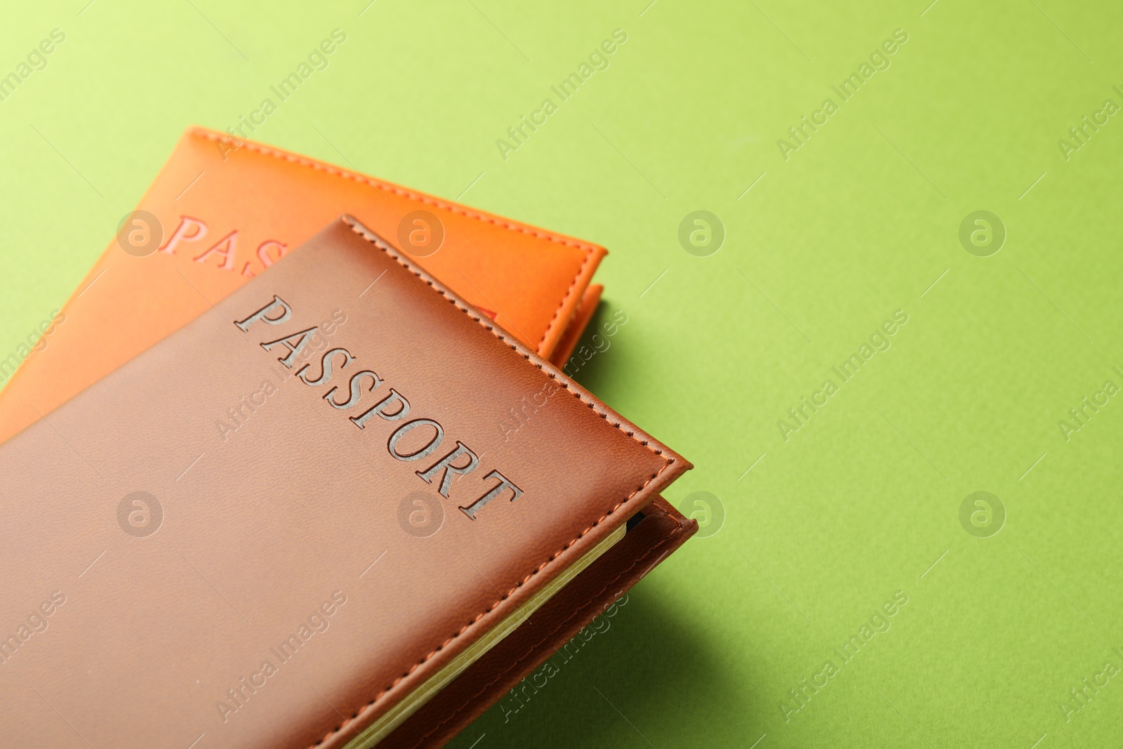 Photo of Passports in color covers on green background, closeup. Space for text