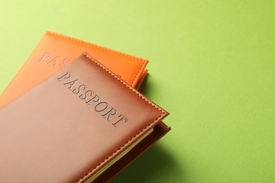 Photo of Passports in color covers on green background, closeup. Space for text