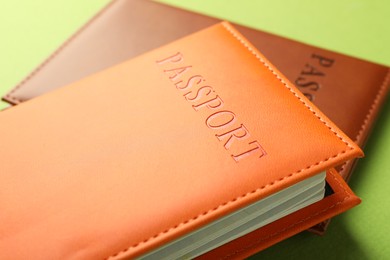 Photo of Passports in color covers on green background, closeup