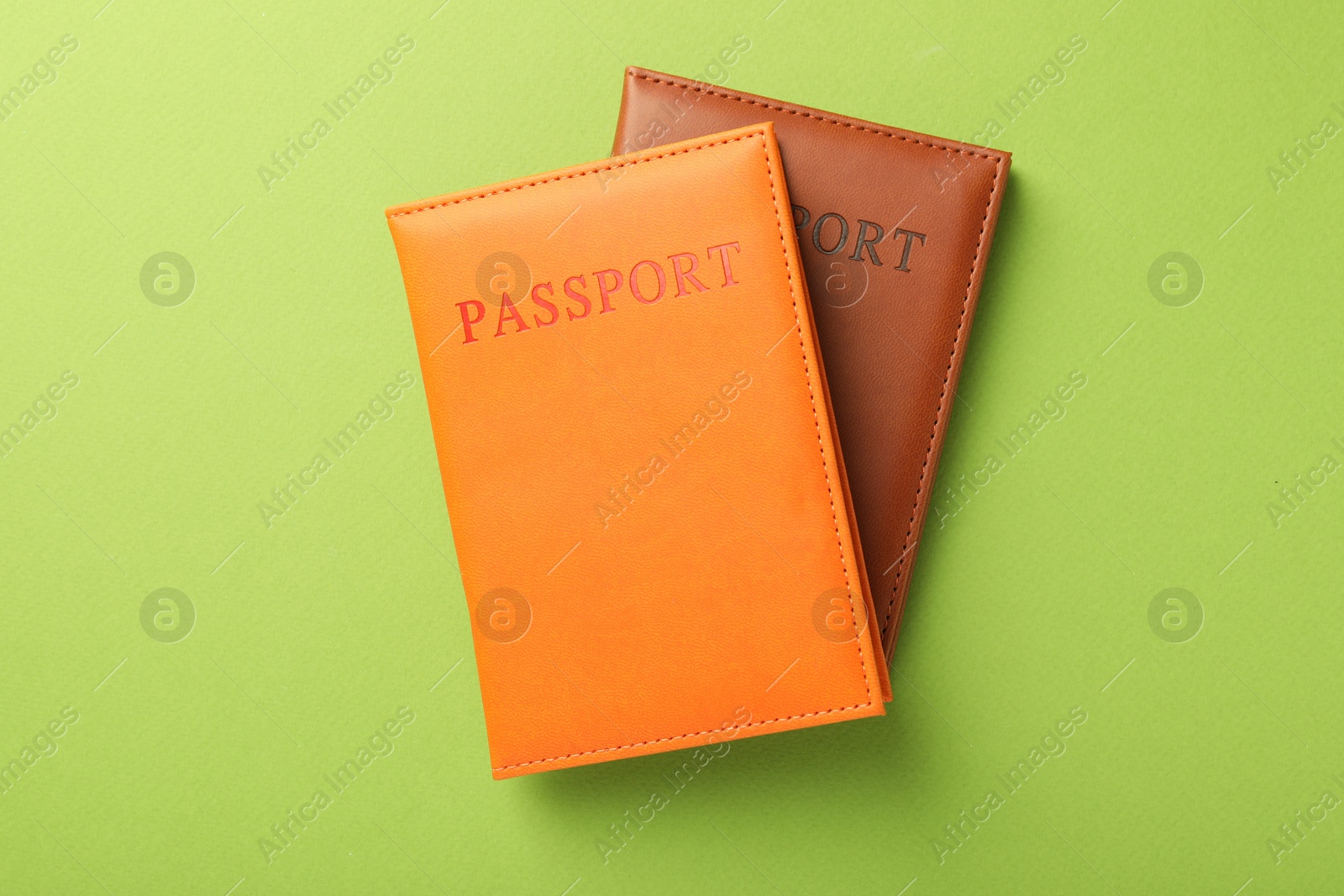 Photo of Passports in color covers on green background, top view