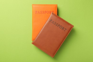 Photo of Passports in color covers on green background, top view