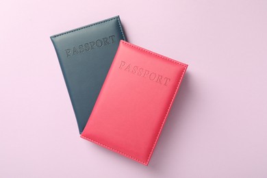 Photo of Passports in color covers on pink background, top view