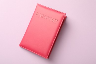 Photo of Passport in bright cover on pink background, top view