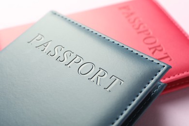 Photo of Passports in color covers on pink background, closeup