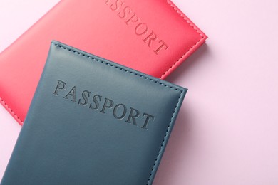 Photo of Passports in color covers on pink background, top view